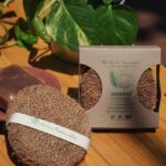 A close-up of a round coconut fiber scrubber made from natural coir, placed inside a stainless steel bowl. The eco-friendly scrubber is made from biodegradable coconut husk, ideal for sustainable kitchen cleaning.